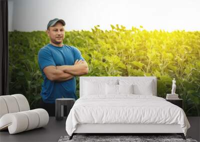 A farmer stands against the background of an agricultural field of sunflowers, selective focus, panorama. Agronomist on agricultural land Wall mural