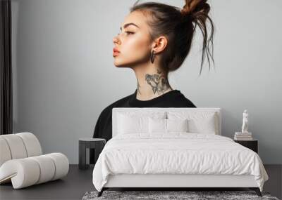 Girl with neck tattoo wearing oversized black T-shirt in urban fashion aesthetic on grey background Wall mural