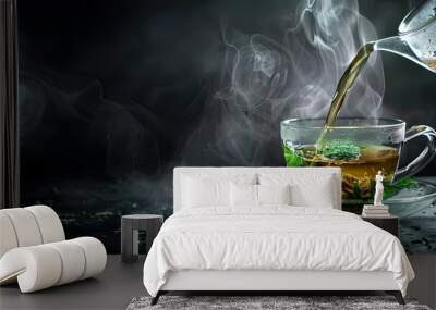 Hot Chinese green tea with mint in transparent cup, pouring from teapot into cup, steam rising, dark background, selective focus, copy space Wall mural