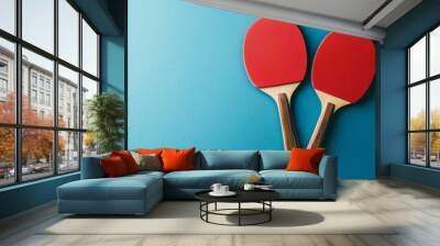 Two red table tennis paddles on a blue background in a minimalistic flat lay style Wall mural