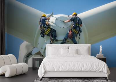 Inspection engineers preparing to rappel down a rotor blade of a wind turbine in a North German wind farm on a clear day with blue sky. Wall mural