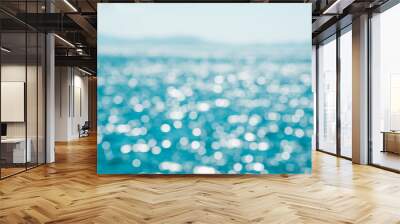 Blurred background of blue water and bokeh of sunlight hitting the sea with Mountain View and clear sky. Summer holiday backdrop.Mock up template for display or montage of product or content. Wall mural