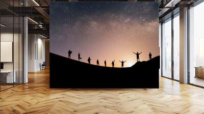 Silhouette group of tourists watch the view of star and milky way on the top of the mountain and raise their hands pointing to the stars before sunrise. We are happy to be with herself and nature. Wall mural