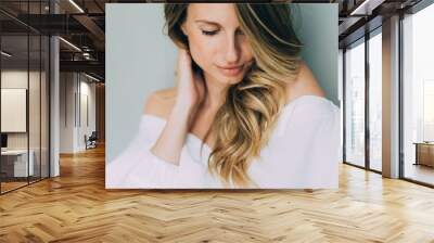 Beautiful elegant sexy woman with curls and full lips girl in a white blouse with volume sleeves. Beauty and fashion style. Soft selective focus. Wall mural