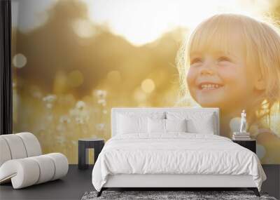 A young girl with a bright smile enjoys a sunny day in a vibrant field filled with blooming flowers under the warm sunlight Wall mural