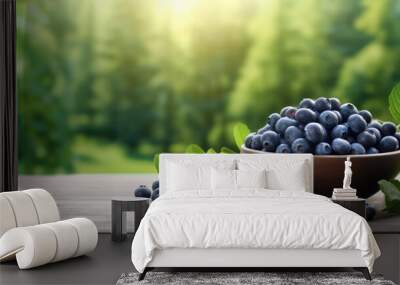 Blueberries in a bowl on a wooden table, blurred green background. Wall mural