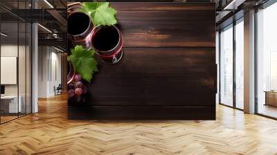 Glasses of red wine and red grapes on a dark wooden table. View from above Wall mural