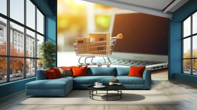 Model shopping cart and laptop keyboard on wood table in office. Morning sunlight Wall mural