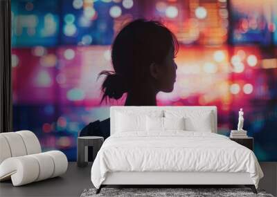 Silhouette of a woman watching vibrant city lights at night, creating a captivating and dreamy urban scene. Wall mural