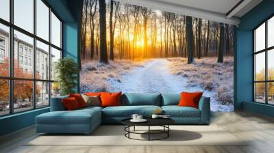 The tranquil path leads through a snowy forest, illuminated by the warm glow of the rising sun in the early morning Wall mural