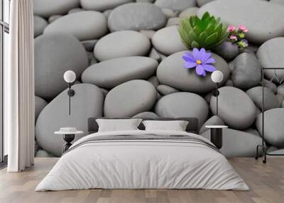 stones, flowers and a leaf are arranged by each other on a blue water surface Wall mural