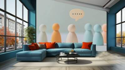 A group of colorful wooden figurines standing together with a speech bubble above them, representing teamwork, communication, and community discussions. Wall mural