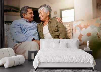 Happily retired ever after. Shot of a happy older couple relaxing on the sofa together at home. Wall mural