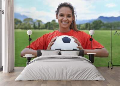 In it to win. Shot of a young female soccer player holding a soccer ball. Wall mural