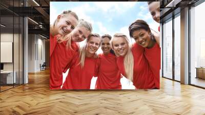 We are ready to win. Portrait of an all-girls soccer team standing arm in arm outside. Wall mural