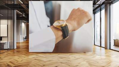 businessman checking time on his wrist watch, man putting clock on hand Wall mural