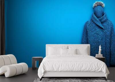 A blue sweater with a hat on top of it Wall mural