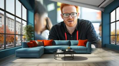 A man with glasses and red hair is talking to a group of children Wall mural