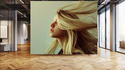 Close-up of a long-haired blonde's face against a simple neutral background. The concept of improving the appearance of hair, revealing femininity and attractiveness, developing a hairdressing busines Wall mural