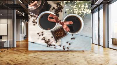 Cups of black coffee. Wedding rings in a drawer of the coffee grinder with coffee powder. Proposals to get married Wall mural