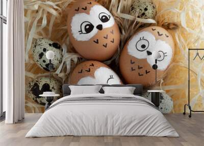 Cute owls in the nest. Brown Easter eggs, quail eggs on yellow straw. Wall mural