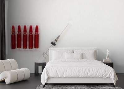 Top view of ampoules and syringe with vitamins group B for injection and copy space on the white background Wall mural