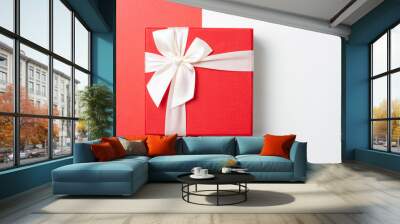 Gift in red box with white ribbon on red and white background, top view Wall mural