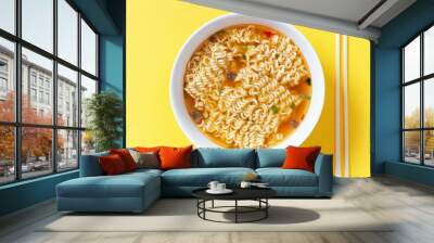 Instant noodle soup in a white bowl on yellow background top view. Wall mural