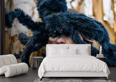 A huge black shaggy toy spider on a woman's head closes her eyes. Halloween Party Costumes and Decorations Wall mural