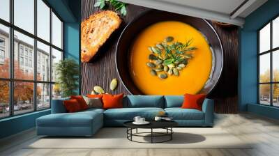 Homemade pumpkin soup with seeds and dill on rustic wooden table Wall mural