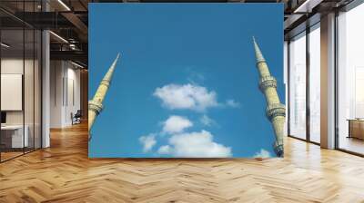 Bottom view Panorama with two minarets of an old mosque against the blue sky. Copy space for lettering. Wall mural