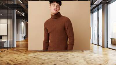 portrait of a young man posing in brown sweater self confidence fashion isolated background unaltered Wall mural