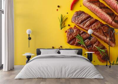 Grilled steaks with herbs and spices on a bright yellow background. delicious grilled beef slices with chili pepper and rosemary, top view. Wall mural