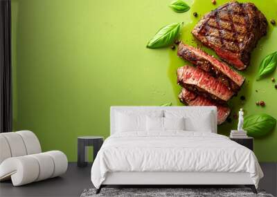 Sliced grilled steak on green textured background with basil leaves and peppercorns juicy medium-rare beef steak presentation for food photography and culinary design Wall mural