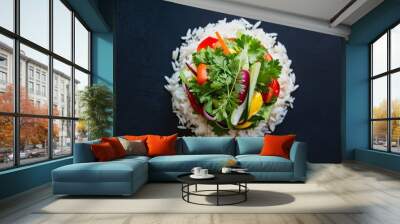 Top view of a fresh salad with rice and vegetables on a dark background, with space for text. A healthy meal option. Wall mural