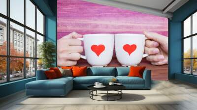 Two white mugs with drawn hearts on the pink background, love concept. Wall mural