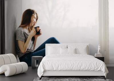 Beautiful girl is dreaming by the window Wall mural