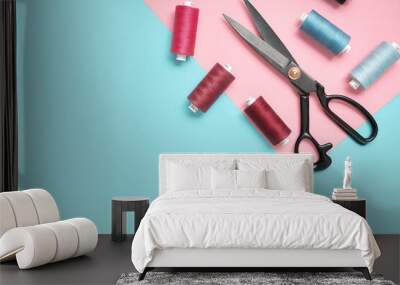 Colored thread rolls and Scissors for sewing on two tone background. Flat lay Wall mural