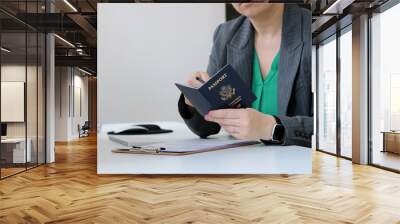 Close up of a caucasian woman holding an American passport at office table Wall mural