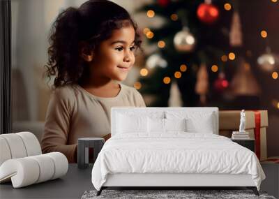 Cute little girl unwrapping Christmas gift, blurred background with lights Wall mural