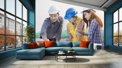 Asian engineers were consulted together and plan in construction site Wall mural