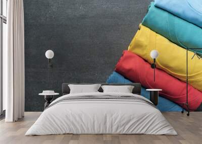 close up of rolled colorful clothes on black background Wall mural