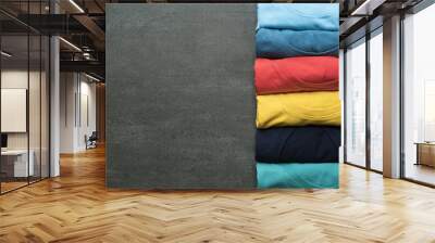 close up of rolled colorful clothes on black background Wall mural