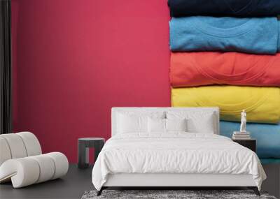 close up of rolled colorful clothes on red background Wall mural