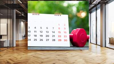 Time for exercising calendar and dumbbell on the table background, sport and healthy concept Wall mural