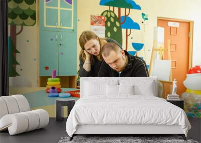 a psychologist is engaged with an adult autistic man in the office Wall mural