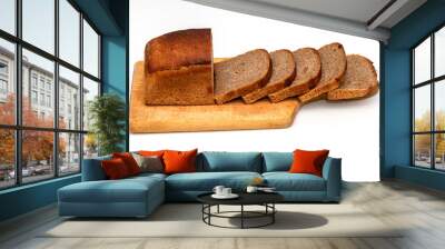 Slices of dark wholemeal bread next to a loaf on wooden chopping board Wall mural