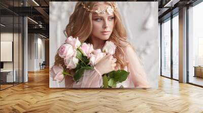 Delicate portrait of a young model girl. The image of the bride, a light lace dress in pink, a beautiful hairstyle and a natural make-up. Light photo studio, natural light from the window. Wall mural