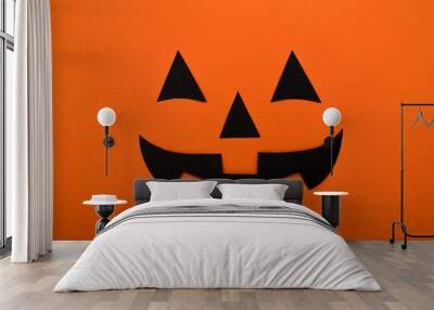 Black eyes,nose and mouth of black paper on an orange background.Halloween concept. Wall mural