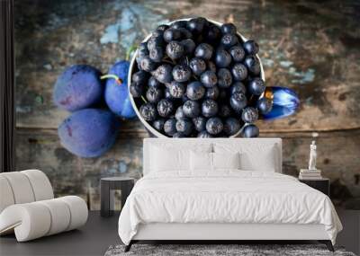 black rowan berries in a mug on a background of an old wooden tabletop Wall mural